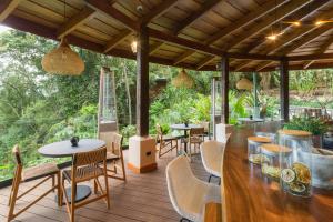 蒙泰韦尔德哥斯达黎加Koora Monteverde-a Cloud Forest Hotel by Sandglass的木制甲板上配有桌椅的庭院
