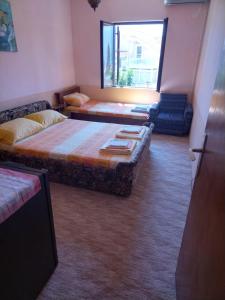 赫尔采格诺维Sobe Baosici Marina的客房设有两张床、一张沙发和一个窗口。