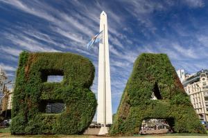 布宜诺斯艾利斯Top Rentals Downtown的塔前有两株植物的纪念碑