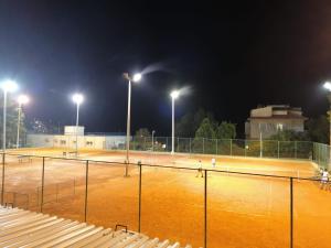 斯普利特Split Ruža Apartment的网球场在晚上点亮,灯光照亮