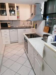 斯普利特Split Ruža Apartment的厨房配有白色橱柜和白色瓷砖地板。