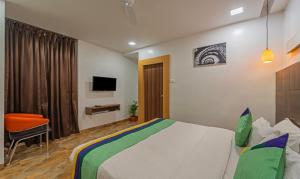 TambaramTreebo Trend Golden Swan Tambaram的一间酒店客房,配有一张床和一台电视