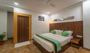 TambaramTreebo Trend Golden Swan Tambaram的一间卧室配有一张带绿色枕头的大床