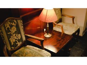 姶良市VAN CORTLANDT HOTEL - Vacation STAY 17475v的一张桌子、一盏灯和两把椅子,一张桌子和一盏灯