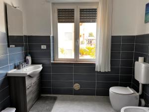 贝加莫Camere Giulia的一间带水槽和卫生间的浴室以及窗户。