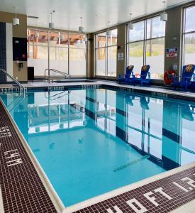 基洛纳基洛纳机场福朋喜来登酒店的一座带蓝色椅子的大型游泳池