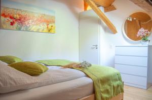 特里贝格Wellness mitten in der Wasserfallstadt Triberg的卧室配有一张床,墙上挂有绘画作品