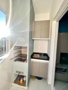 乌巴图巴Apto. novo, todo equipado, 330m da praia的小厨房配有白色橱柜和炉灶。