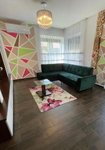 德布勒森Exkluzív Apartman Debrecen的客厅配有绿色沙发和地毯。