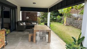 圣吉尔莱班Villa HIMANI的庭院配有木桌和沙发。