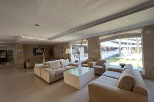 皮拉尔－德拉奥拉达达帕尔梅拉海滩酒店的客厅配有白色家具和大窗户