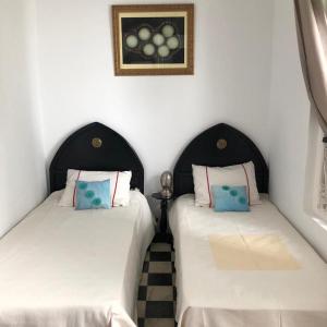 丹吉尔达纳科拉莱西利亚酒店的两张睡床彼此相邻,位于一个房间里