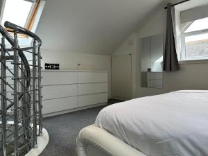 Ardeer SquareSeaside Home的一间卧室配有床和白色梳妆台