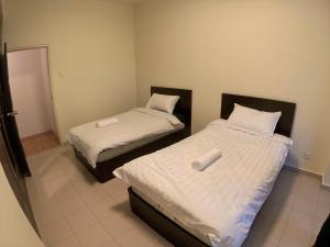 吉隆坡Bukit Bintang Fahrenheit88 Apartment by Sarah's Lodge的客房内的两张床和白色床单