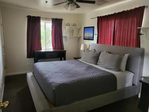 佩吉Tail Wind Life LLC的一间卧室配有一张带红色窗帘的大床
