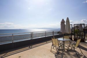 比雷埃夫斯天蝎座海滨酒店的一个带桌椅的海景阳台