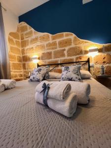 圣维托罗卡波Celeste Rooms的石墙客房的两张床