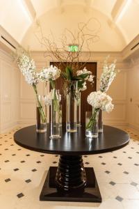 达拉斯Hôtel Swexan的一张黑色桌子,上面有花瓶