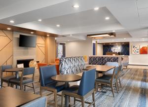 普兰菲尔德印第安纳波利斯机场智选假日酒店的一间设有桌椅和电视的等候室