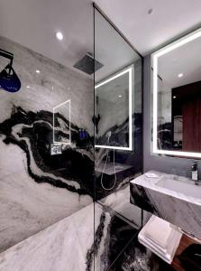 布拉索夫Radisson Blu Aurum Hotel, Brasov的带淋浴和盥洗盆的浴室