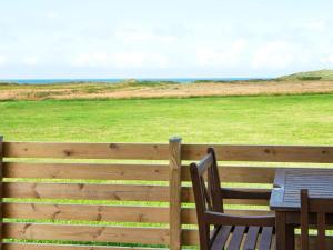 Trans6 person holiday home in Lemvig的享有田野景致的围栏上的桌椅