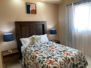 佩尼亚斯科港Ancla Suite 2 - 2 Bedroom Urban Hotel的一间卧室配有一张床、两盏灯和一个窗户。