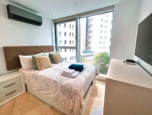 直布罗陀Luxury 1 Bed - City Suites Ocean Spa Plaza的一间卧室设有一张大床和大窗户