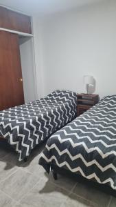拉里奥哈Departamento cómodo的两张睡床彼此相邻,位于一个房间里