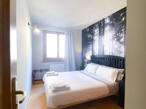 索尔德乌Especial Familias Golden - Soldeu - Parking Gratis的一间卧室配有一张带白色床单的大床
