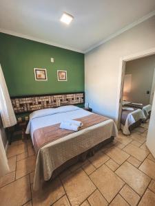 贝卢港沃贾克斯旅馆的一间卧室设有一张床和绿色的墙壁