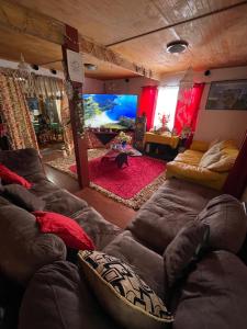 安加罗阿Pua vaenga的一间带大棕色沙发的客厅和一间带沙发的客厅