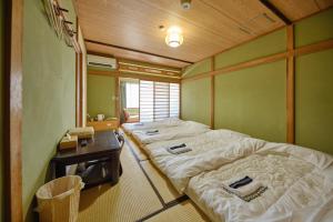 富士河口湖芙蓉山居煙霞ー元富士の屋旅館ー的客房设有两张床和一张桌子
