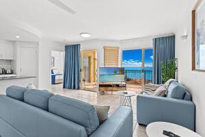 埃尔利海滩Airlie Hasta Manana的客厅配有蓝色的沙发和电视