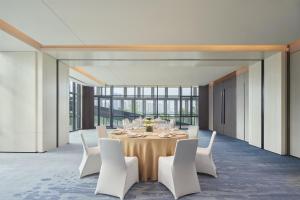 长沙长沙万豪行政公寓的一间带桌子和白色椅子的用餐室