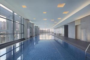 长沙长沙万豪行政公寓的大楼内带窗户的大型走廊,设有游泳池