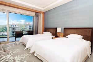 淳安千岛湖喜来登度假酒店的带大窗户的客房内的两张床