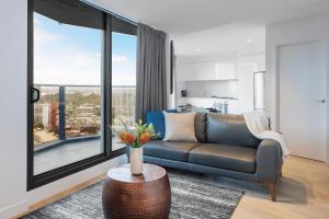 墨尔本马尔科想象公寓的带沙发和大窗户的客厅