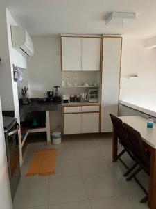 伊利亚贝拉Casas Do Mar的厨房配有白色橱柜、桌子和柜台。