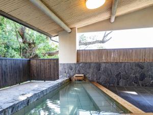 白滨Tabist Nanki Shirahama Ryokan Mantei的后院的游泳池,带有木栅栏