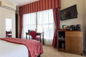 Tuakau图阿栲酒店的酒店客房配有一张床、一张书桌和一台电视。