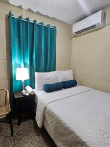 Nueva San SalvadorCat House的一间卧室配有一张蓝色窗帘的床