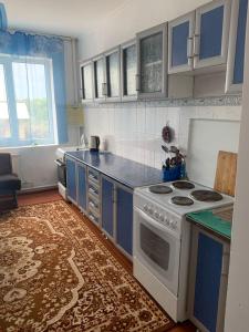 乔尔蓬阿塔Guest House的厨房配有白色炉灶和蓝色橱柜。