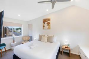 伯马吉Reflections Bermagui - Holiday Park的卧室设有一张白色大床和一扇窗户。