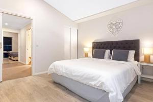 邓斯伯勒Aqua21 @ Cape Villas Dunsborough的白色卧室配有一张带心形床头板的大床