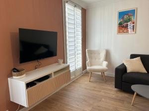 土伦Duplex climatisé proche port Toulon的一间带电视和椅子的客厅