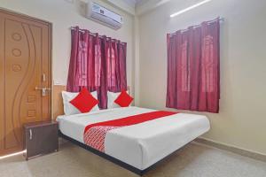 Haidar Sāhibgūda80983G RBS Square Langer Houz的一间卧室配有一张带红色窗帘的床和一扇门