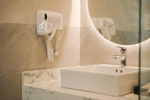 Plei Brel (2)PLEIKU HIGHLANDS BOUTIQUE HOTEL的一间带水槽的浴室和墙上的一部电话