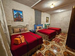 危地马拉安地瓜Casa Miranda的一间设有两张红色床罩的房间
