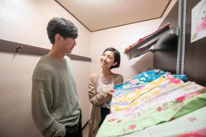 热海Yuyado Ichibanchi的站在床边的男人和女人
