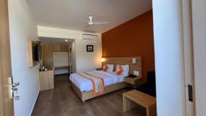 克久拉霍Hotel The Bundela - Khajuraho, Madhya Pradesh的酒店客房,配有床和电视